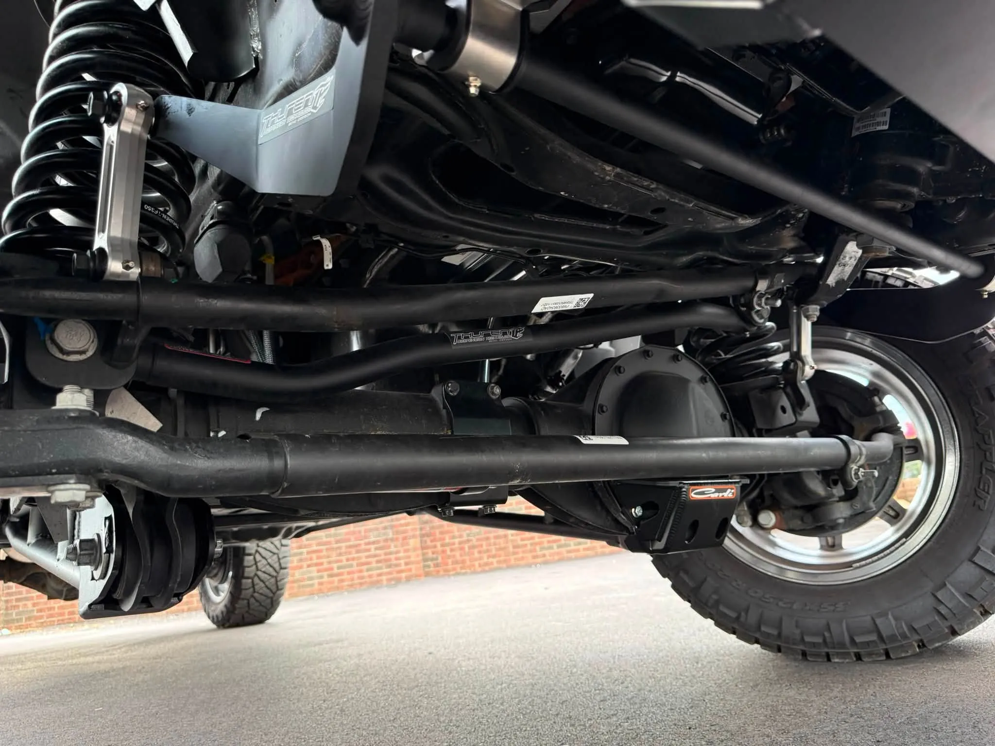 Aftermarket suspension and driveline work underneath a truck